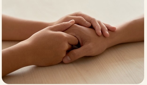 Two hands clasped together in a quiet moment of care